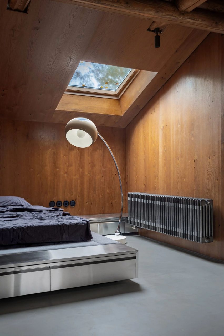 Bed with stainless steel border and warm wood walls