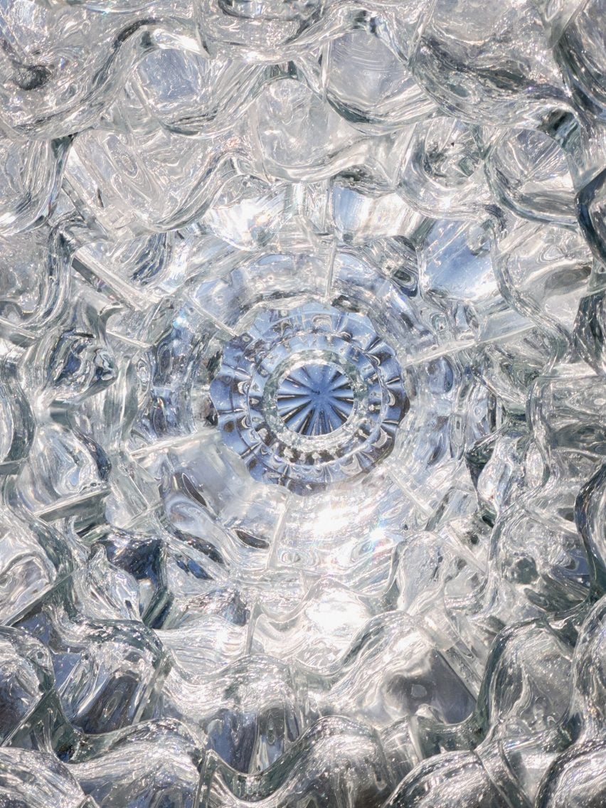 Photo from inside the Serpentine Bell sculpture, looking directly up and showing loops of glass bricks ascending to create a kaleidoscopic view of the sky