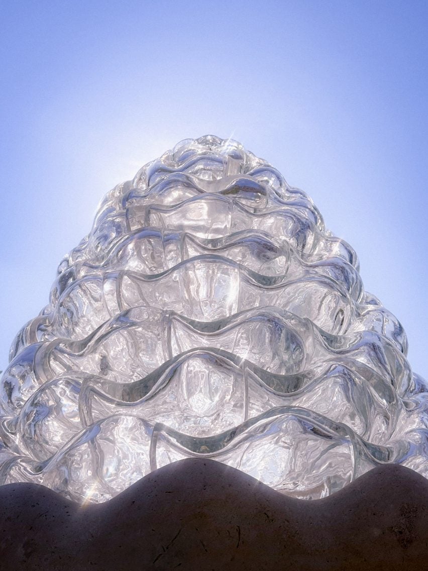 Worm's-eye view photo of the Serpentine Bell sculpture by AAU Anastas lit from behind by the sun