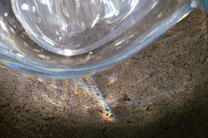 Close-up photo of reflections on a stone surface from a bubble-like glass block by AAU Anastas