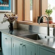 Steel kitchen countertop contrasted against blue cabinets