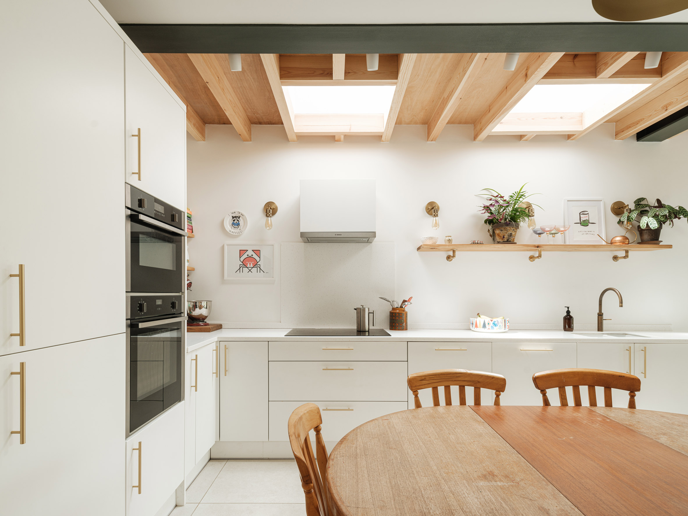 Skylights and oak beams alongside white walls and kitchen cabinets