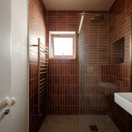 Deep orange tiled shower area