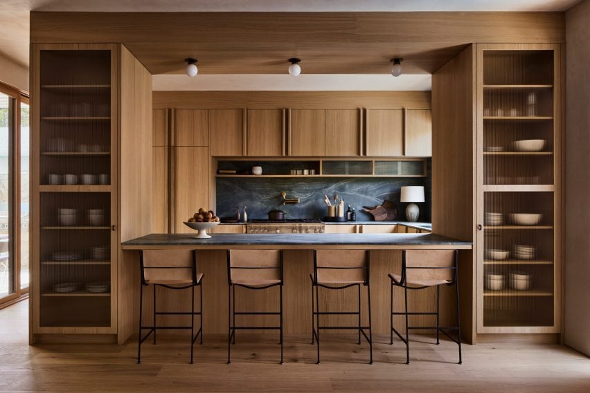 Kitchen with oak cabinetry and blue-green stone counters