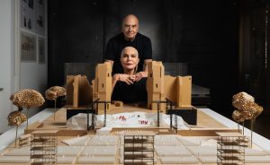 Photo of Massimiliano and Doriana Fuksas in front of a large architectural model for their Tosca and Turandot set