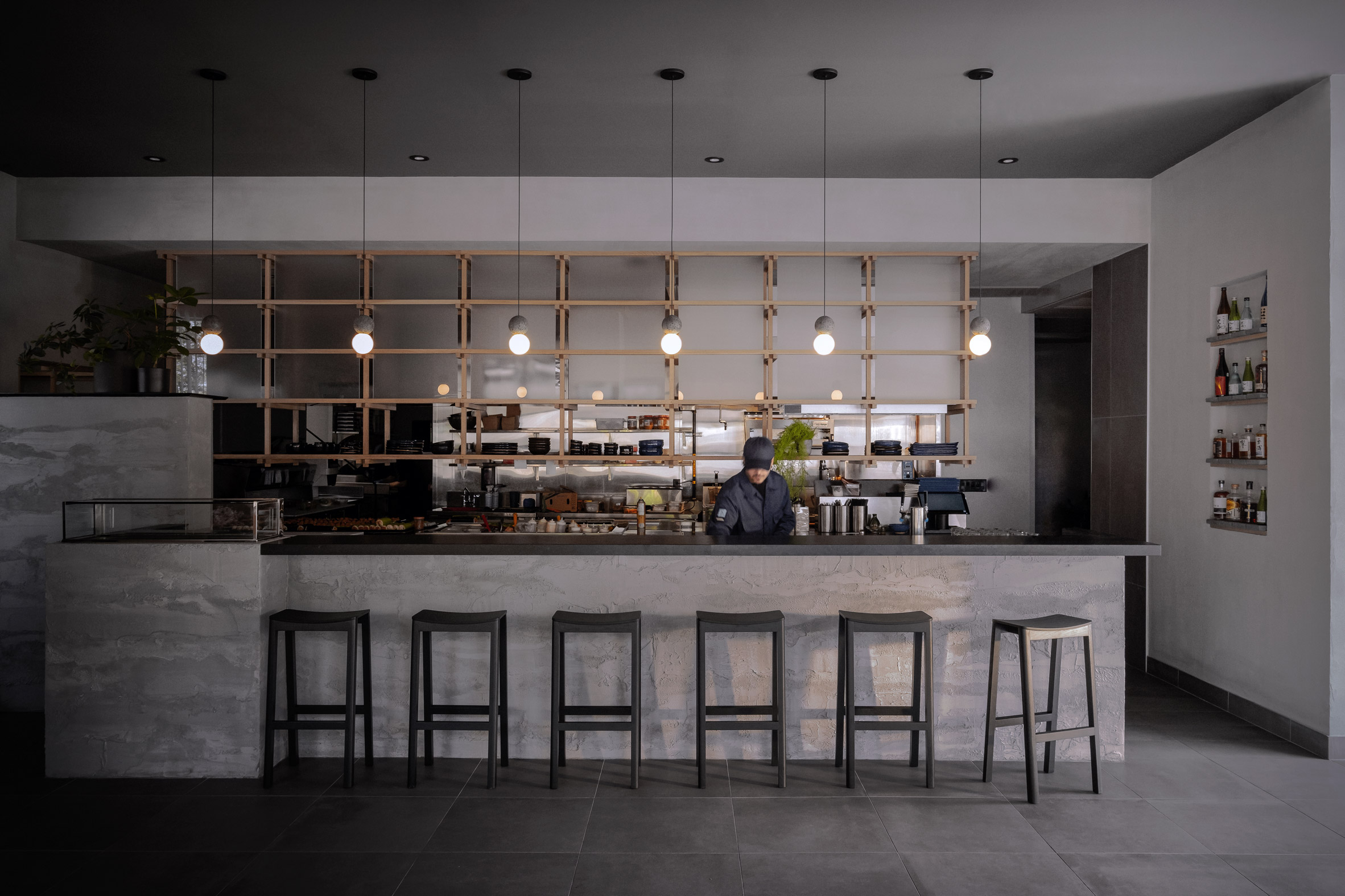 Concrete counter that provides a bar overlooking an open kitchen