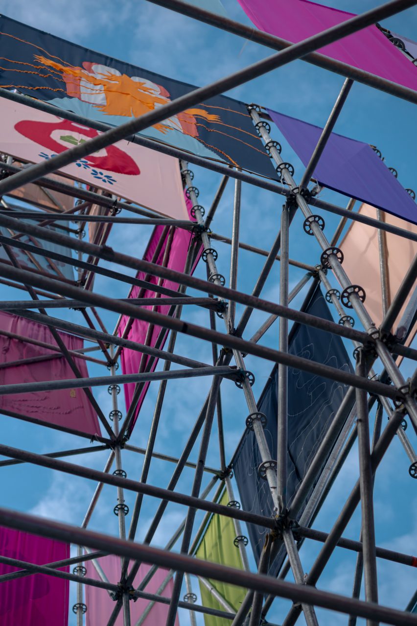 Pyramidal scaffolding structure clad in colourful flags