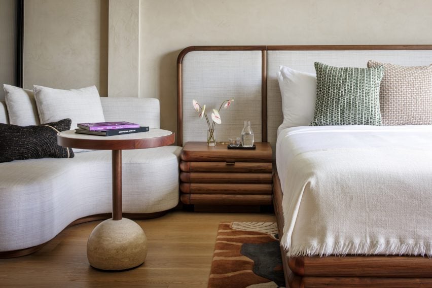 Hotel room with walnut-framed bed and neutral decor