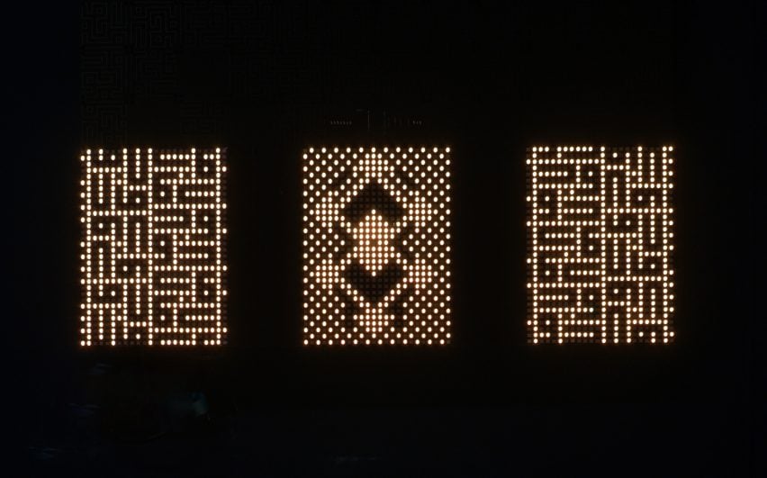 An photograph of three illuminated light patterns within rectangular frames, comprised of grid-like patterns in a warm white tone, against a black backdrop.