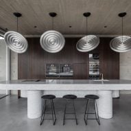 Custom disk-shaped lighting by Tom Dixon were suspended over the kitchen island