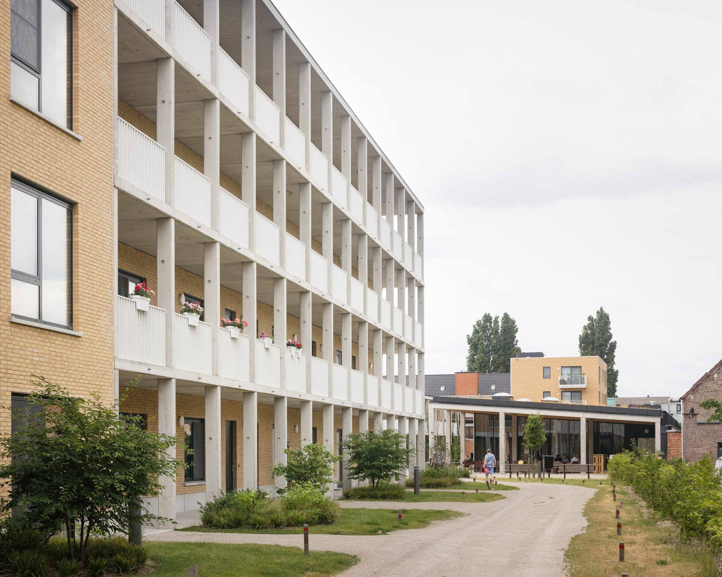 Walkway through housing block by Archipelago and NU Architectuuratelier