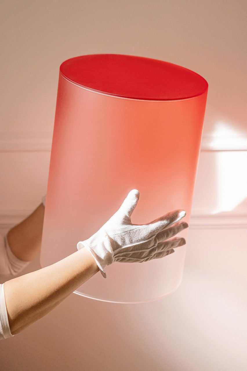 Hands holding an ombre glass cylinder