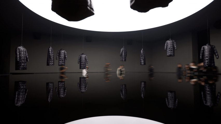 Black jackets hanging from ceiling of installation