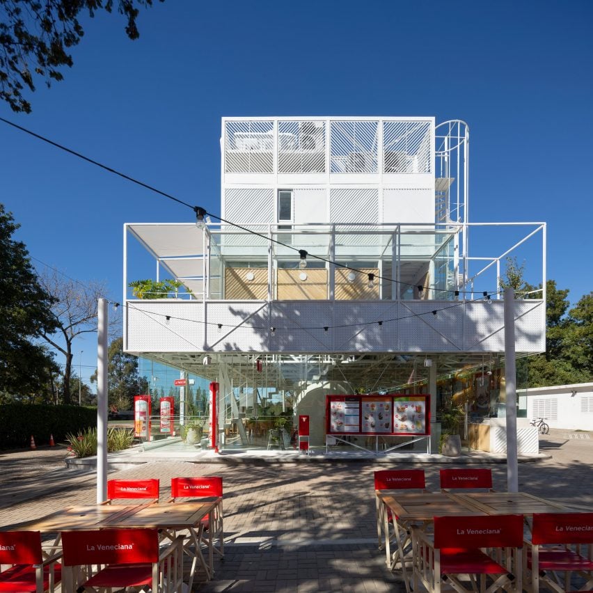 White metal structure building with red chairs in foregrond