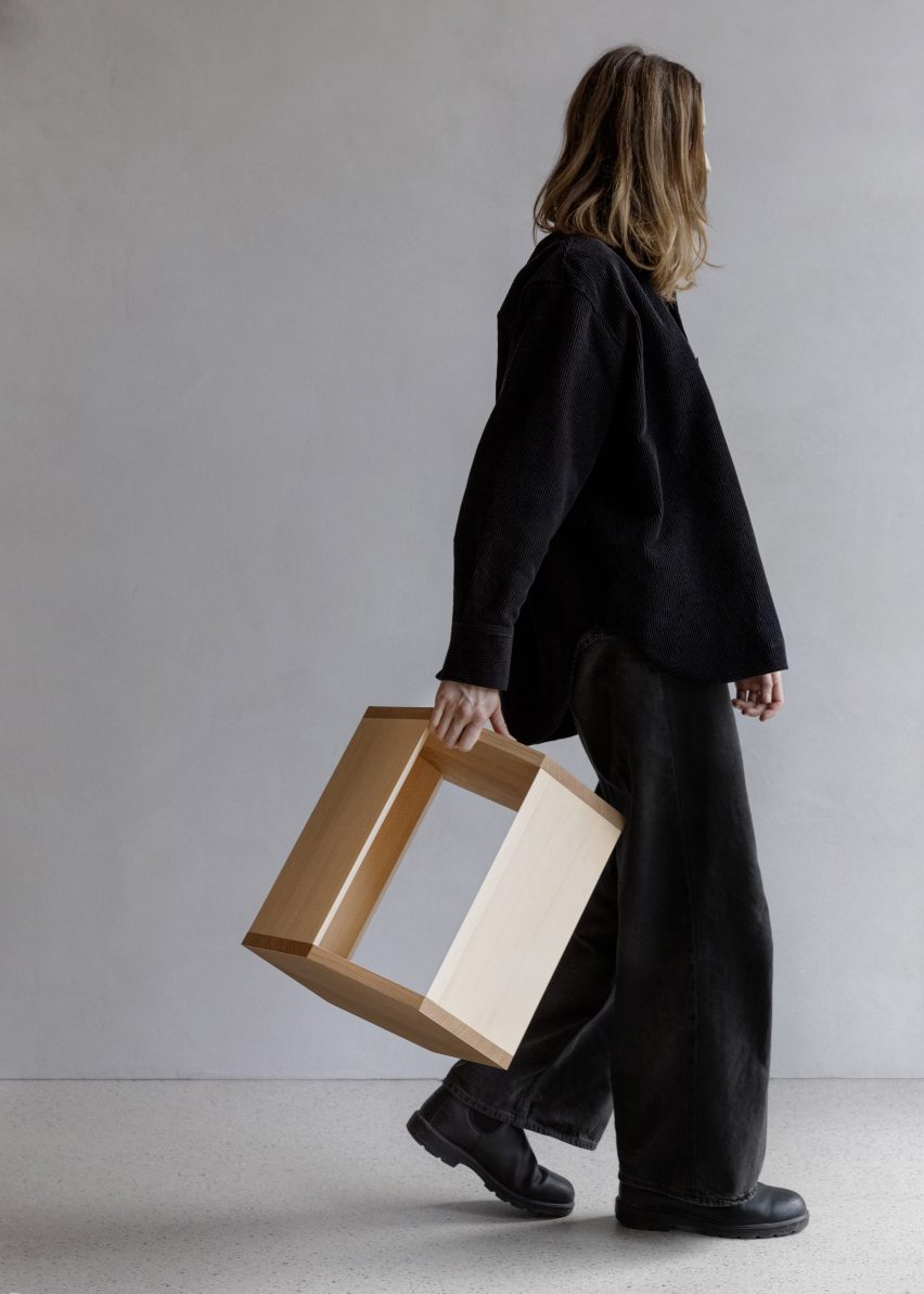 Person dressed in all black carrying table with one hand