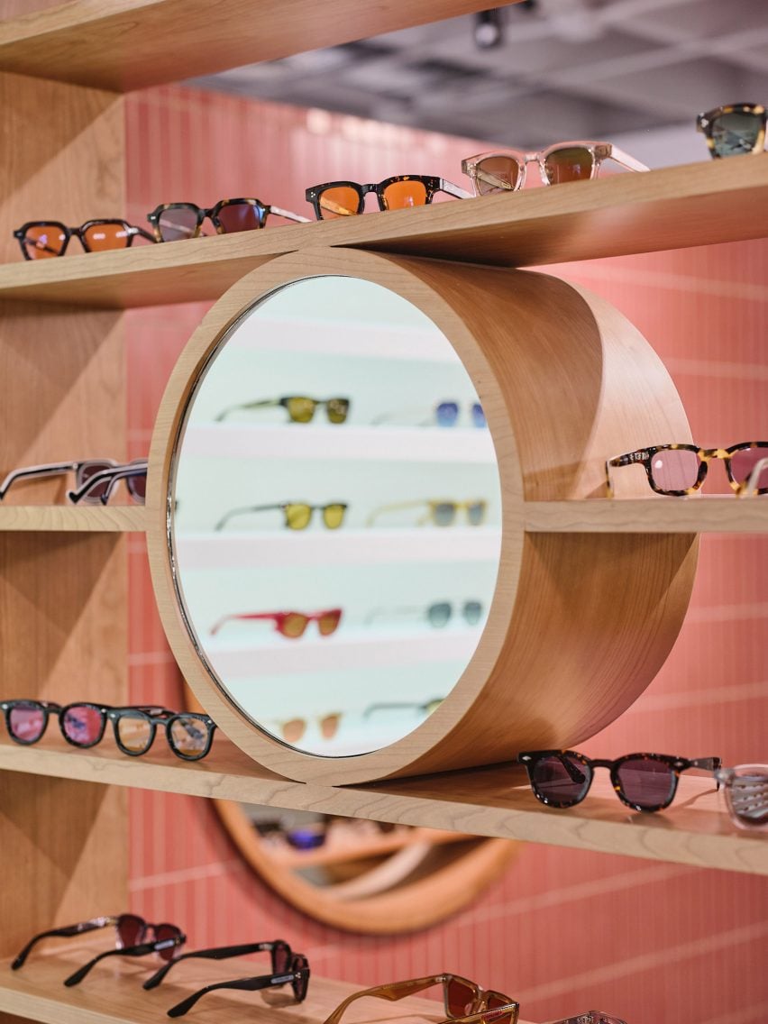 Circular mirror within a wooden shelving unit