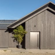 Black timber and metal cloak low-lying Weald House in Kent