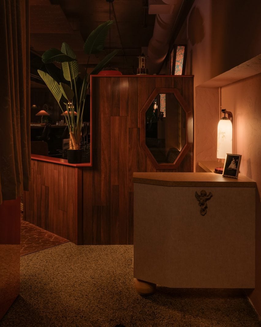 Reception area at Meo restaurant with small desk and dark wood behind