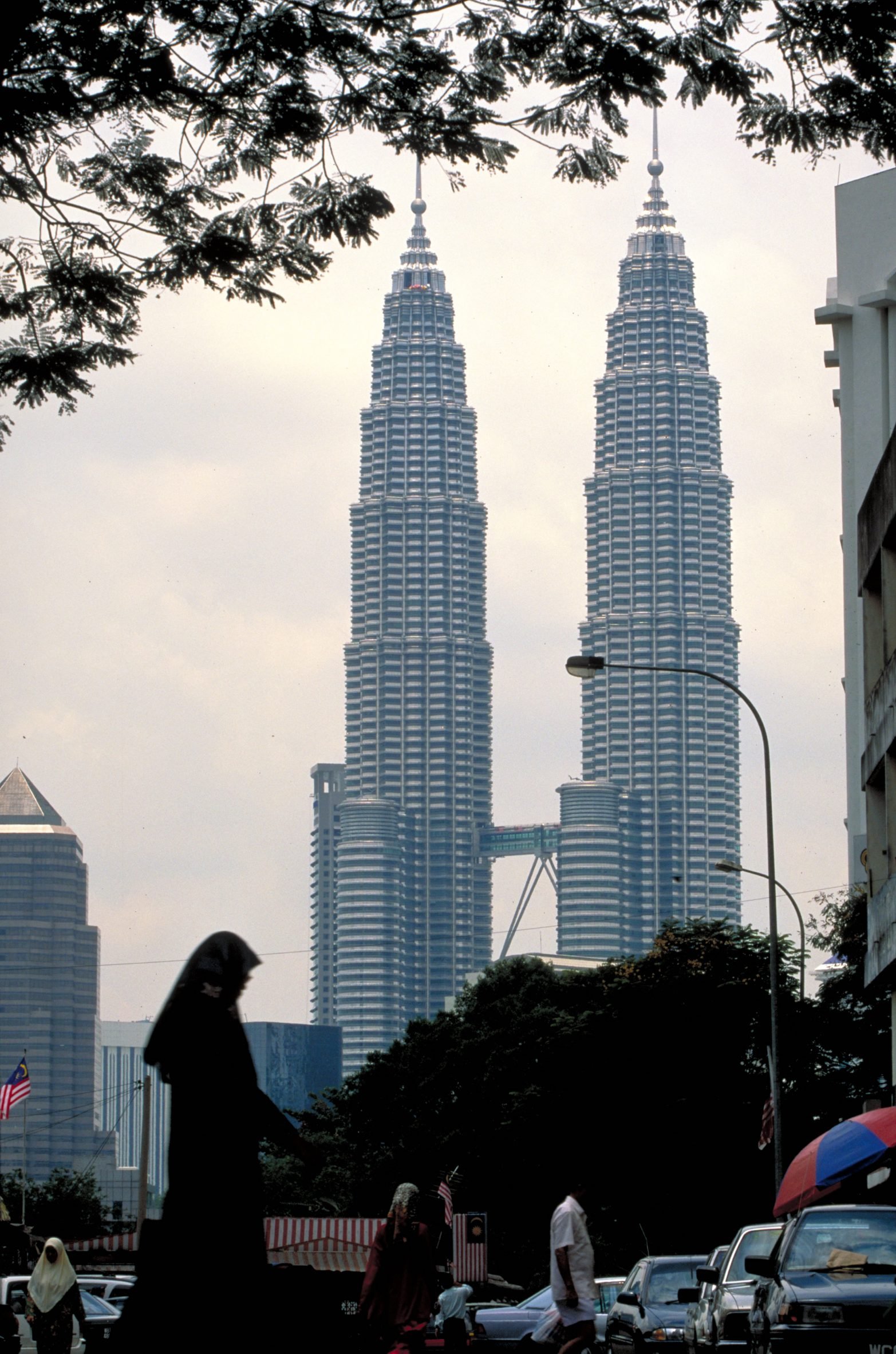 Petronas Towers with woman in a stroller walking in front