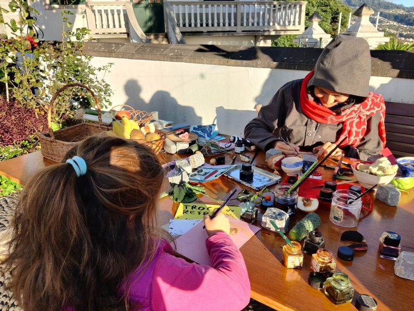 Child and adult painting at a table