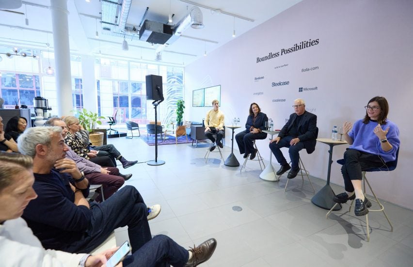 Photo of four panel speakers sitting in front of an audience in a large showroom space