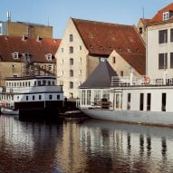 Boats outside canal-side warehouse converted into flats Denmark