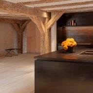 Black kitchen island and fittings topped with orange flowers