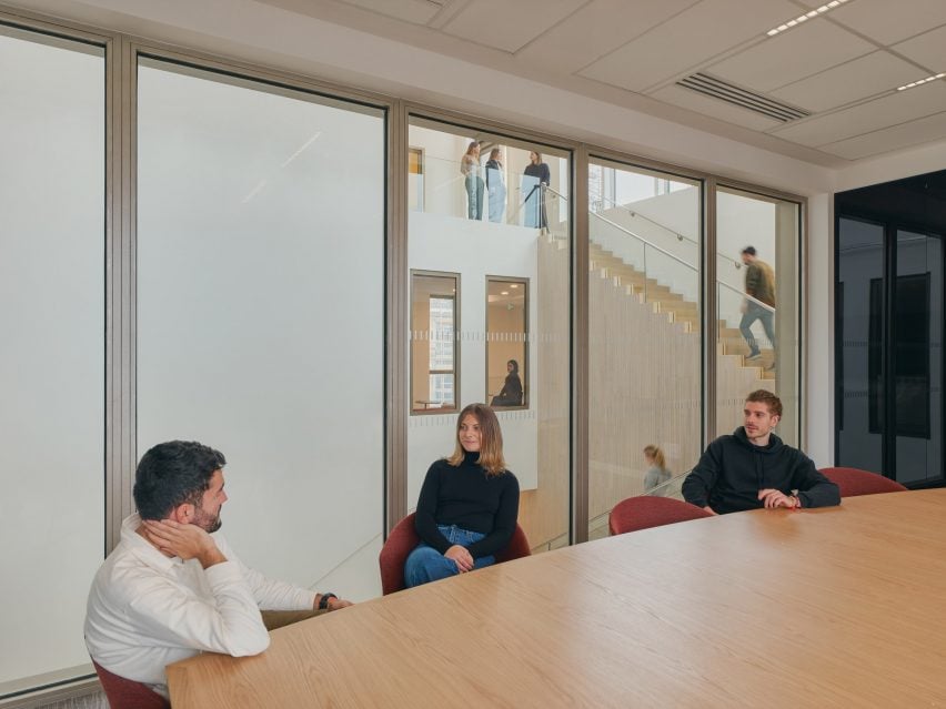 Students at a desk wtih staircase through window in the background