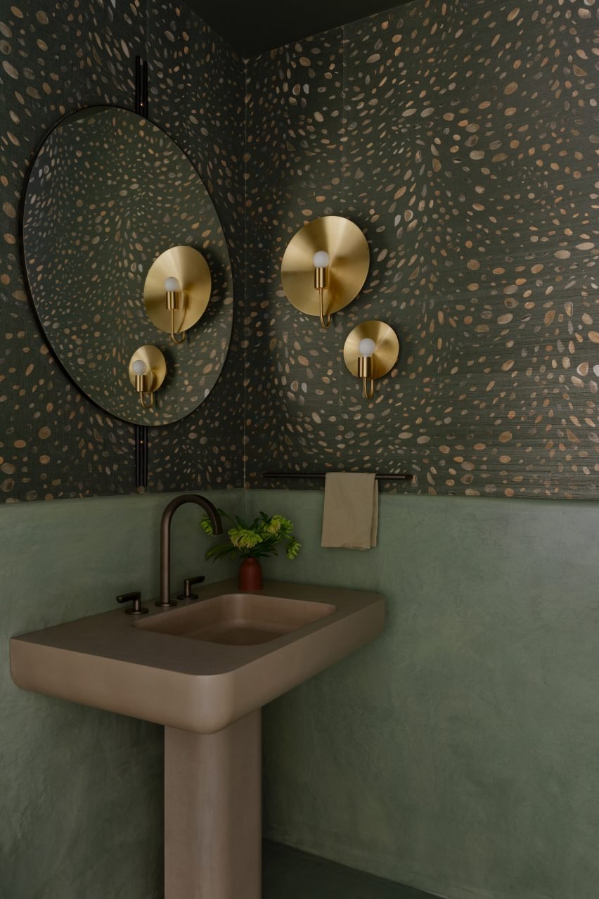 Hallway bathroom with earthy green plaster and brass sconces