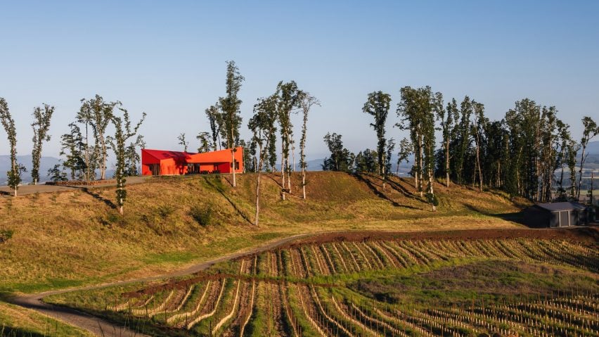 Bâtiment rouge sur la colline au-dessus du vignoble