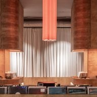 Orange light hanging from ceiling inside listening bar