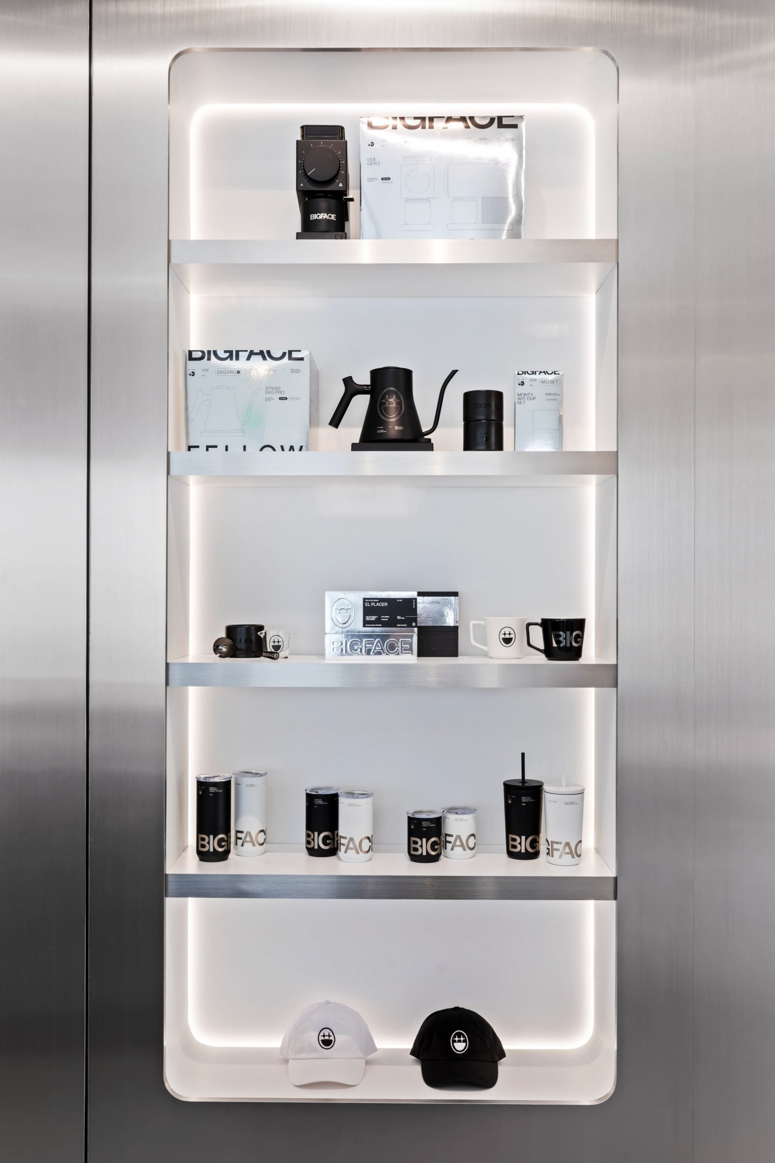 Merchandise displayed inside a backlit niche surrounded by brushed stainless steel