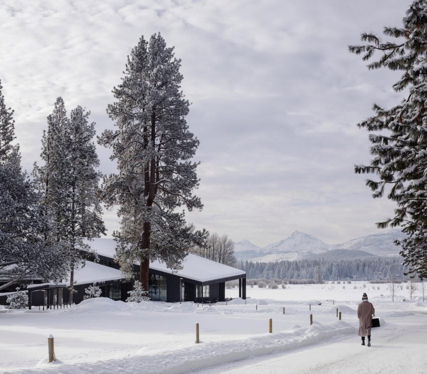 Woman walking in snow towards lodge