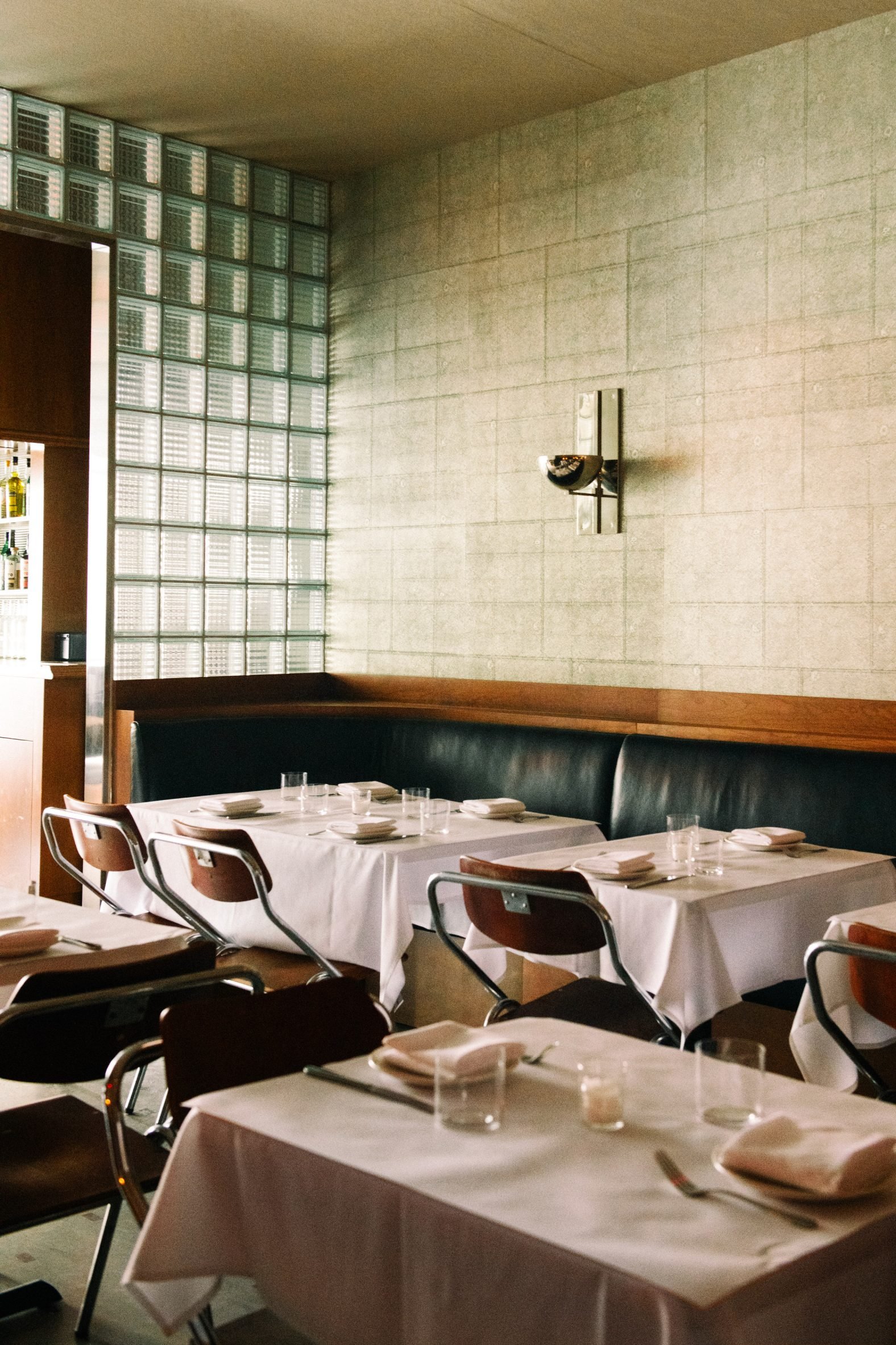 Restaurant with white table cloths and glass block partitions