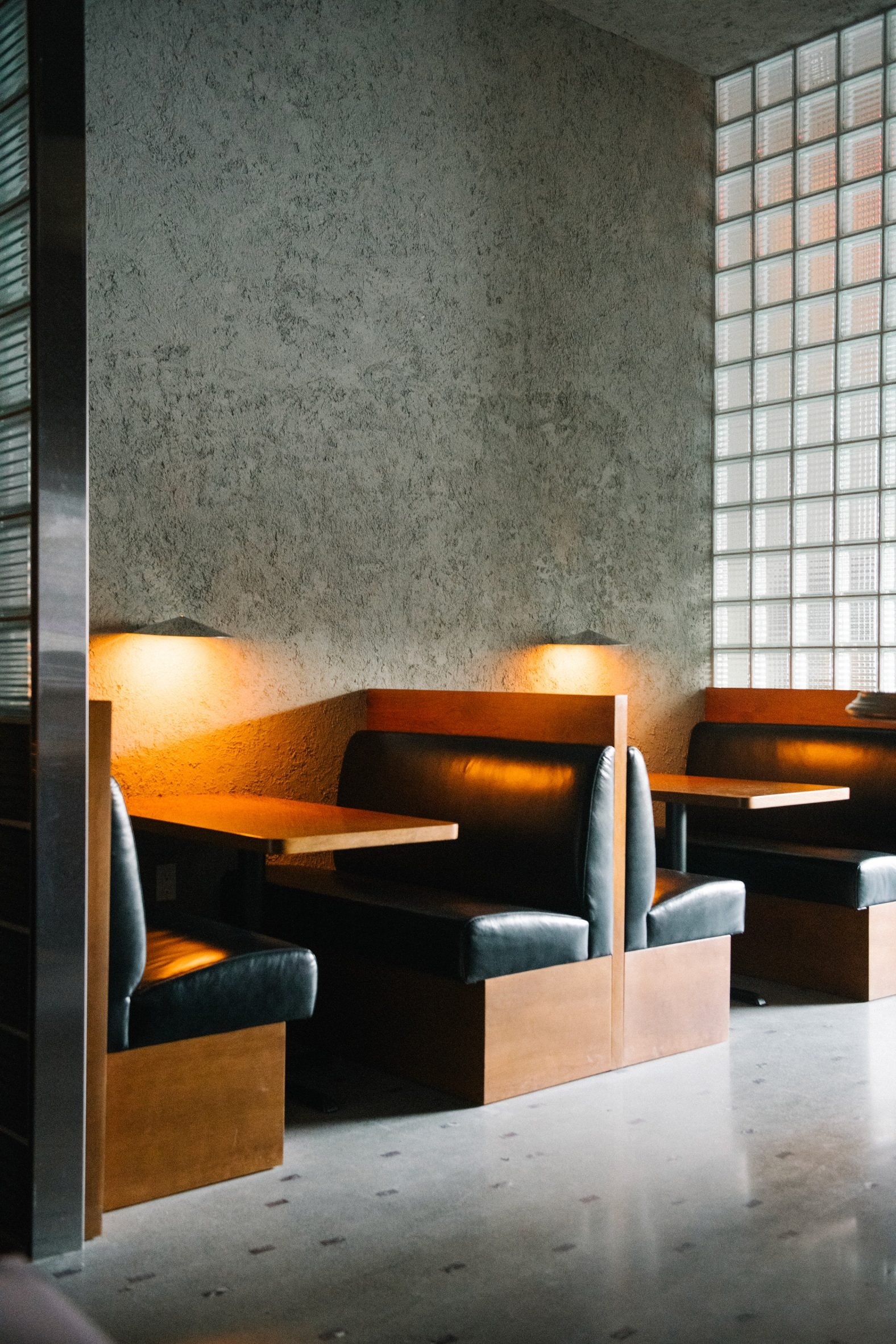 Chrome-finished sconces illuminate a pair of seating booths