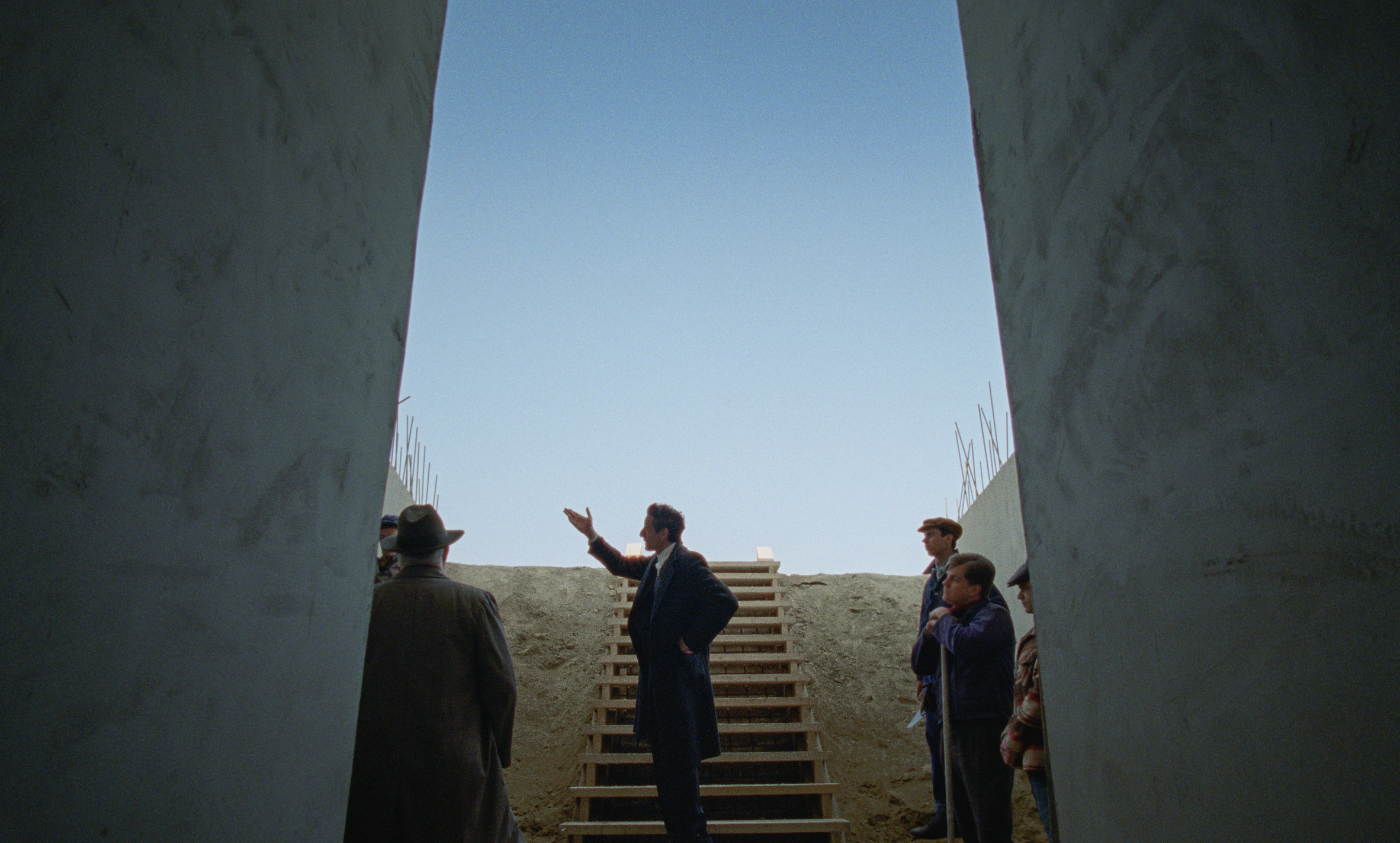 Actors on concrete steps in The Brutalist