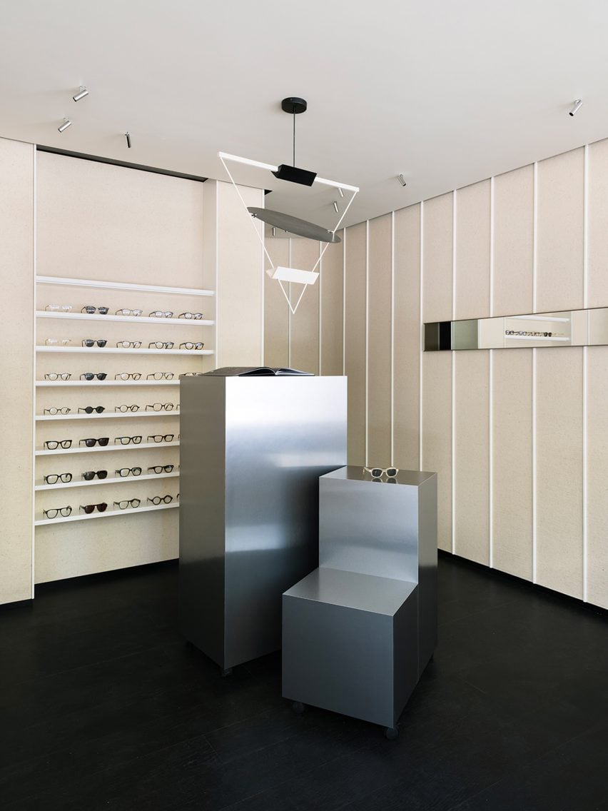 Eyewear store interior with beige felt walls and a black floor