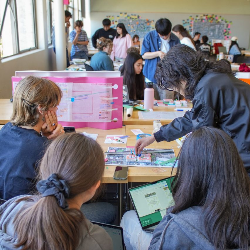 a photograph of students working together around a desk
