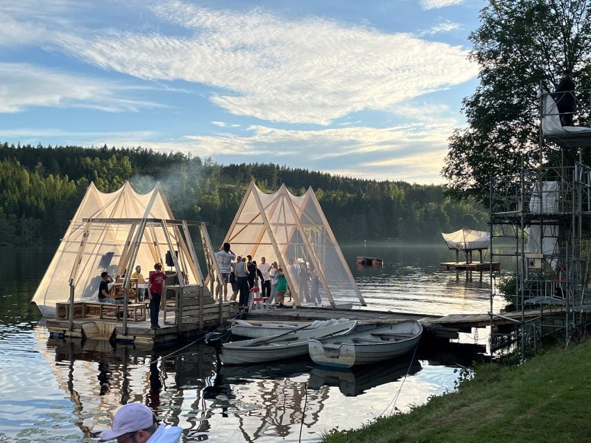 A photograph of two triangular structures on a dock atop a lake.