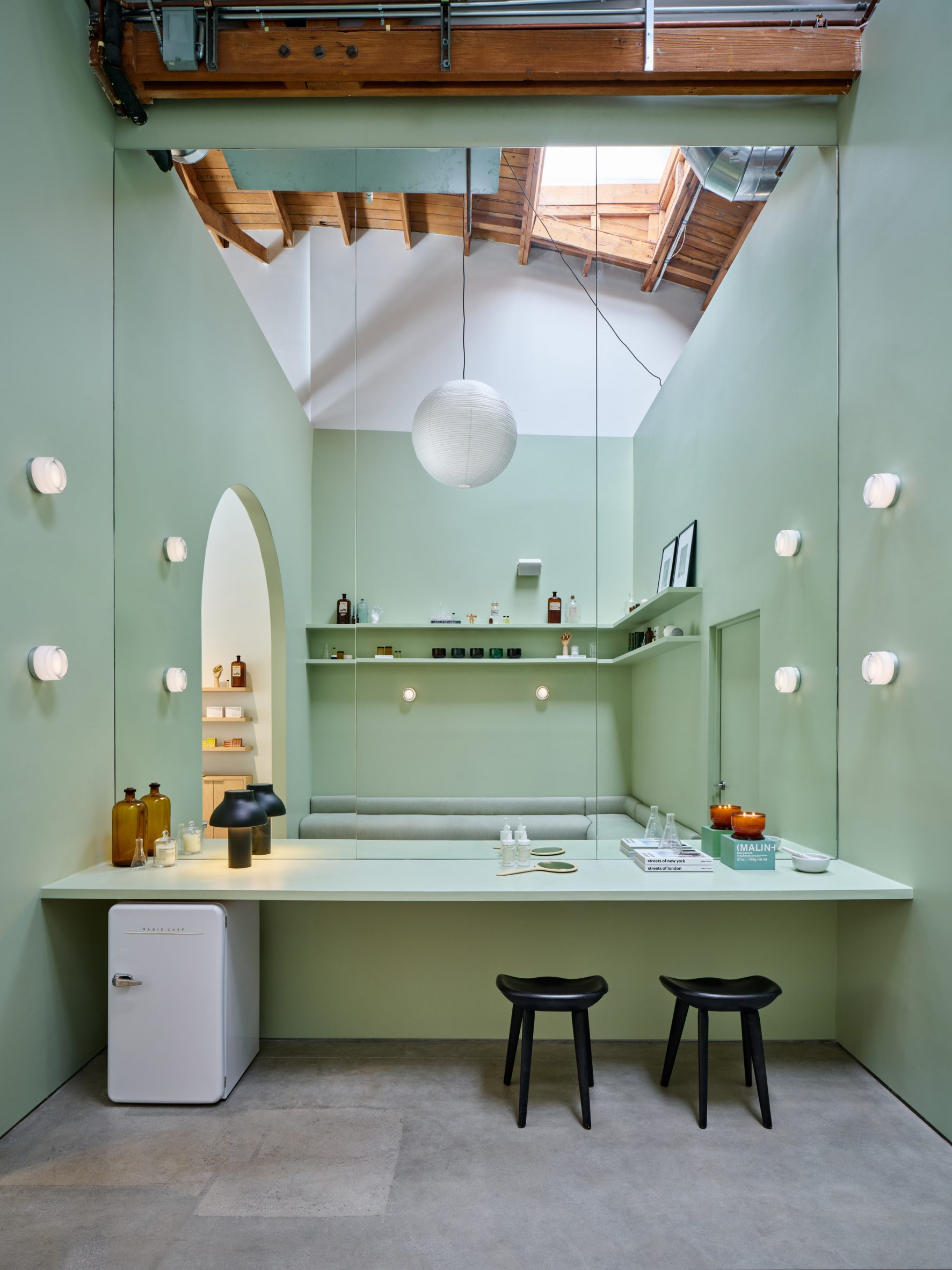 Pale-green space with large mirrors and a vanity desk