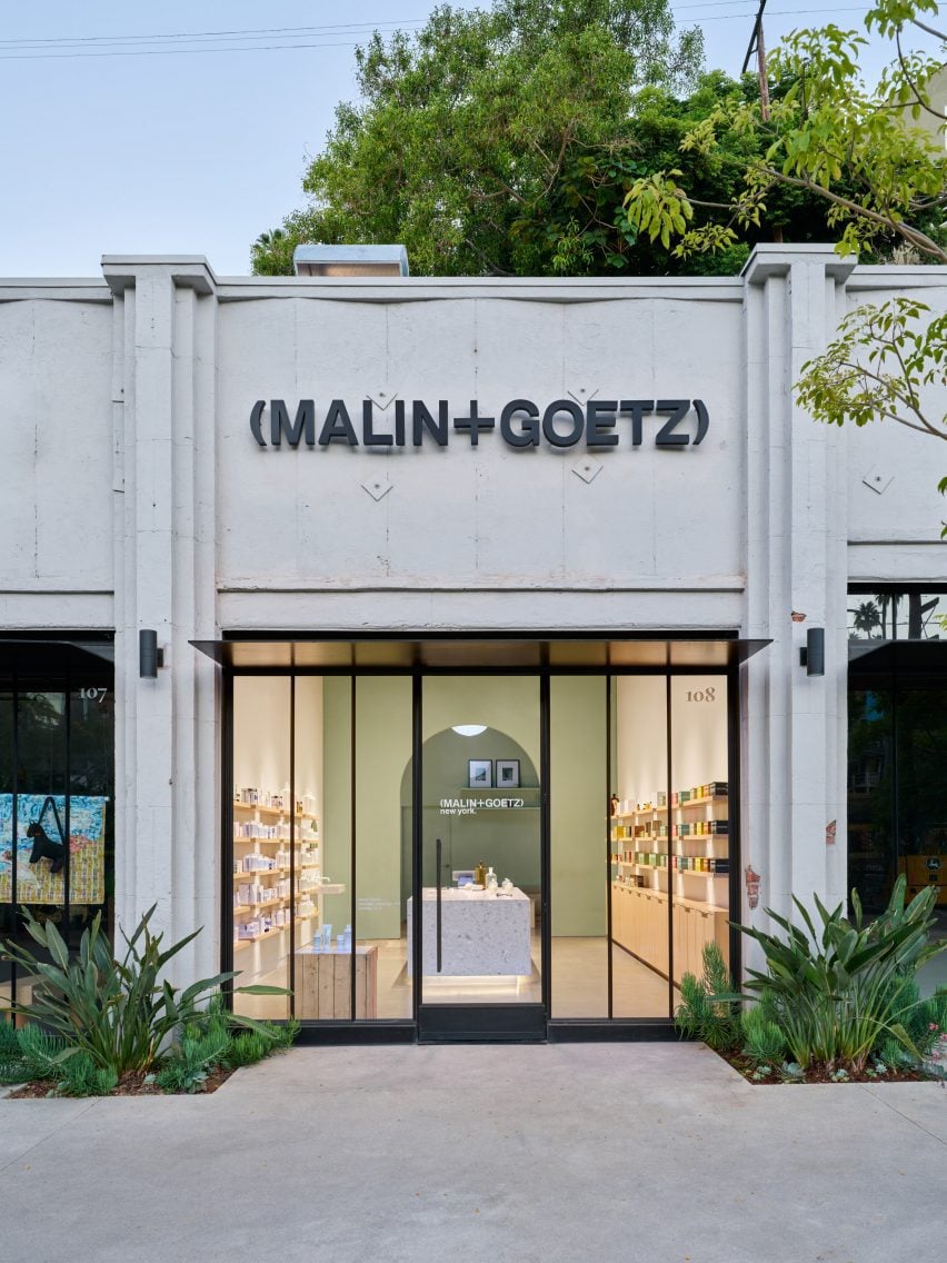 Art deco facade with the Malin+Goetz logo above a glazed storefront