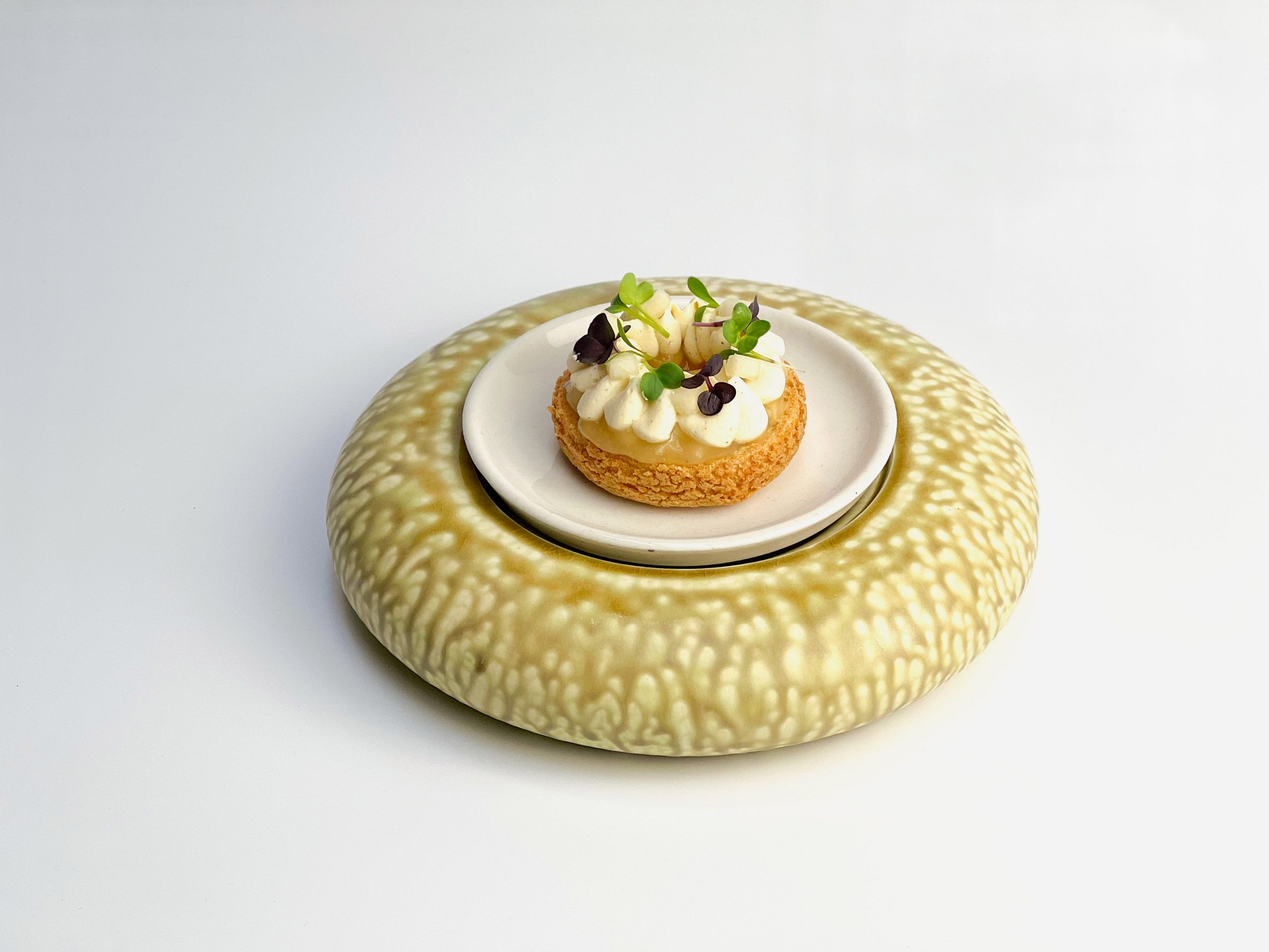 A photograph of a spherical yellow ceramic plate with food on it.