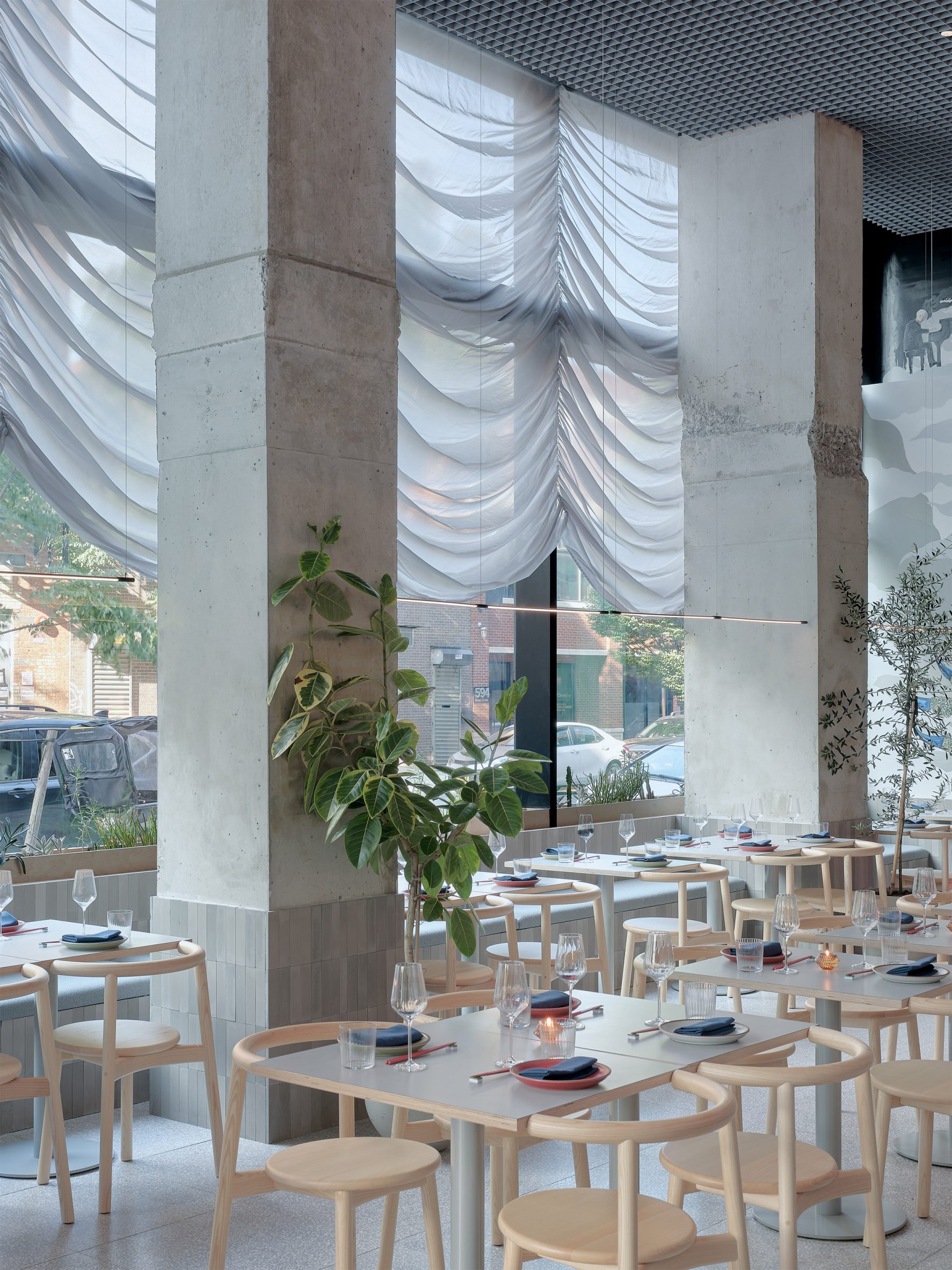 Restaurant with large windows covered with translucent Austrian curtains