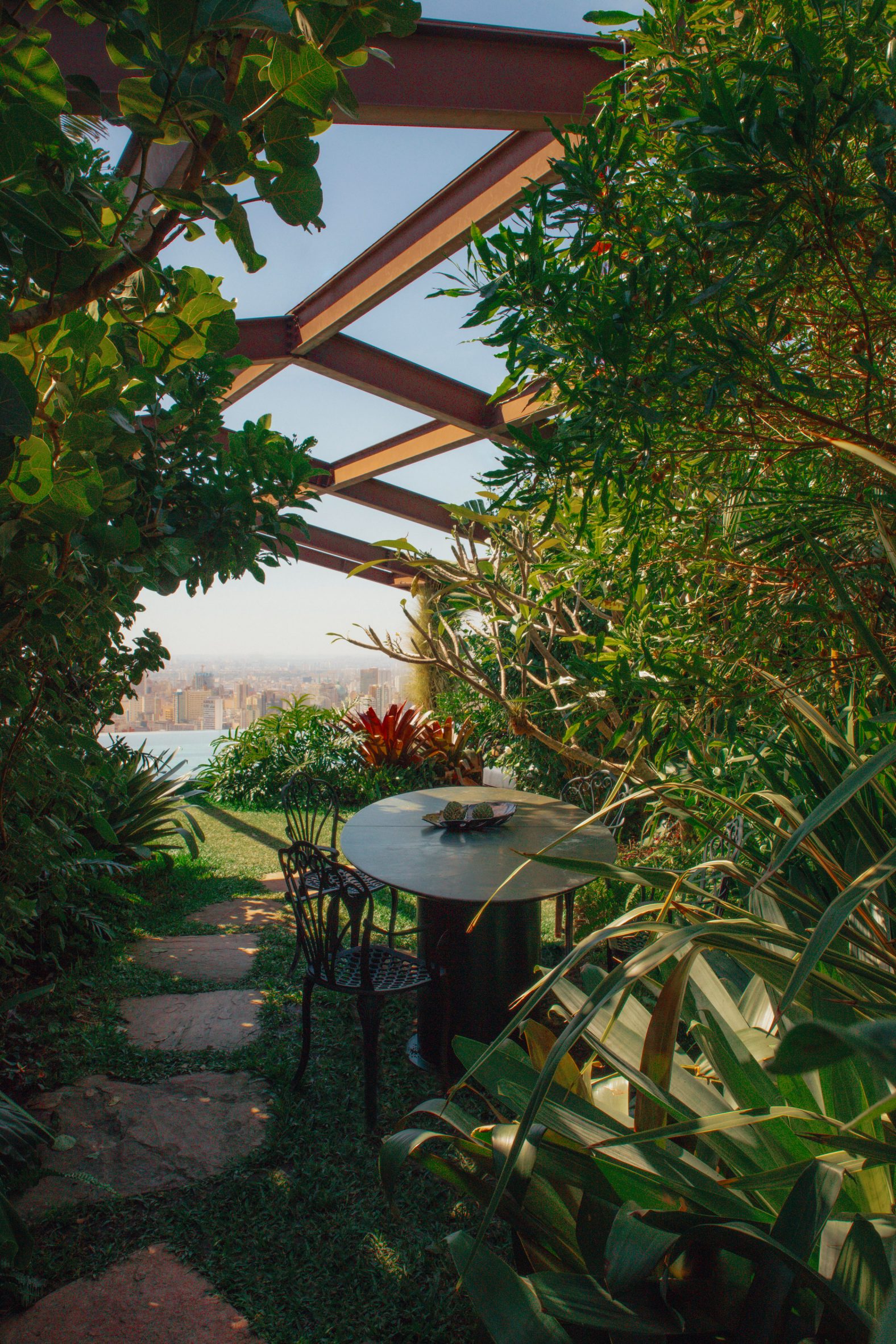 Pathway through jungle-like foliage to a swimming pool