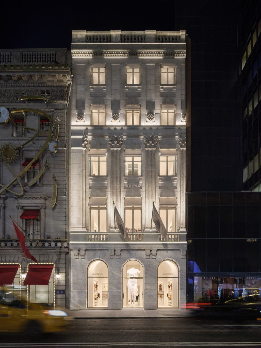 Historic Fifth Avenue building with ornate exterior detailing, seen at night