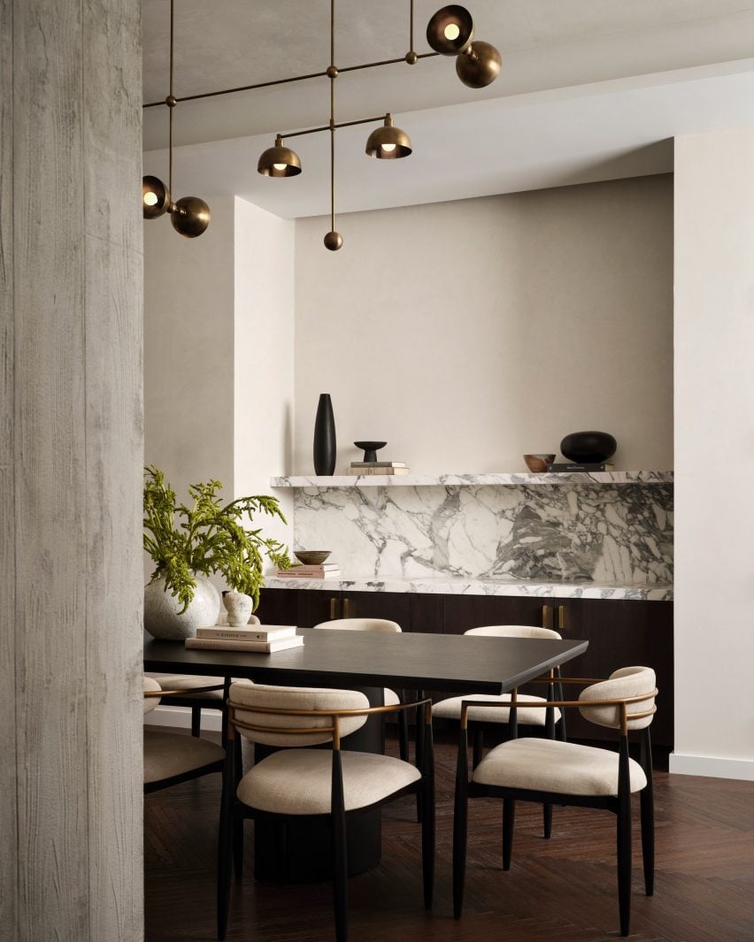 Private dining room with exposed concrete columns and brown oak herringbone floors