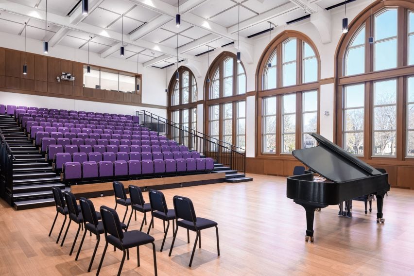 A double-height performance space with retractable purple seating