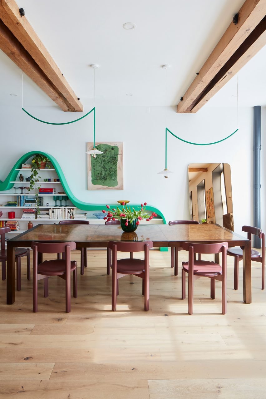 Dining space with a green shelving unit and matching pendant lights