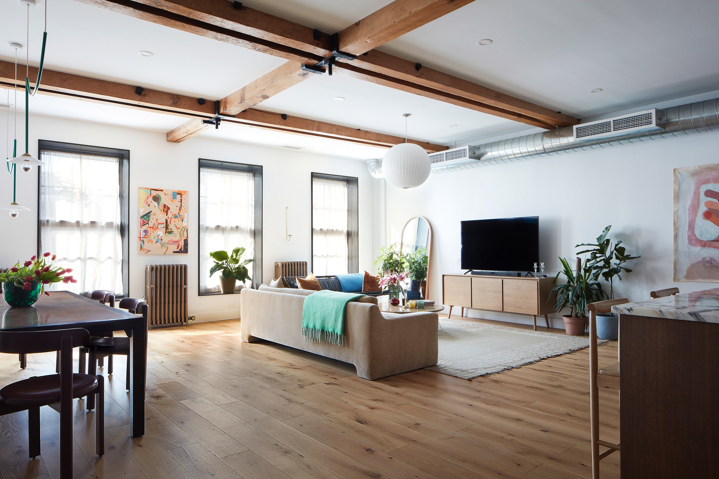 Living room with wooden ceiling beams and exposed ductwork