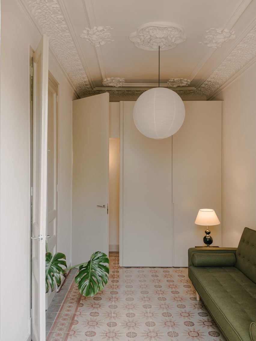 Green sofa and large white wardrobe in apartment